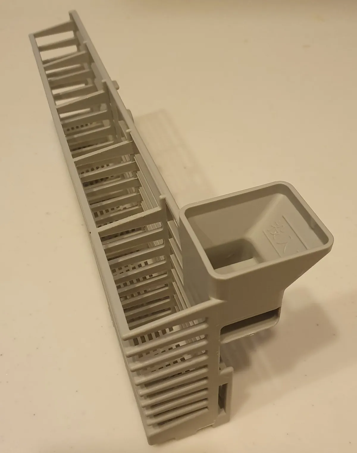 Dishwasher cutlery basket with a detergent holder built into its side