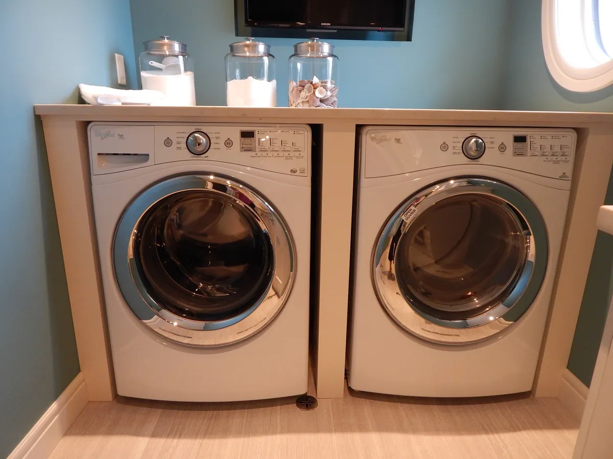 Matching front-load washer and dryer side by side on a raised base