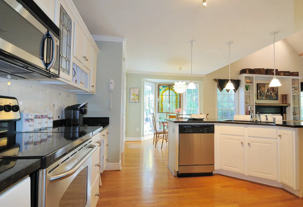 Kitchen with a built-in stainless microwave over a range, next to a dishwasher