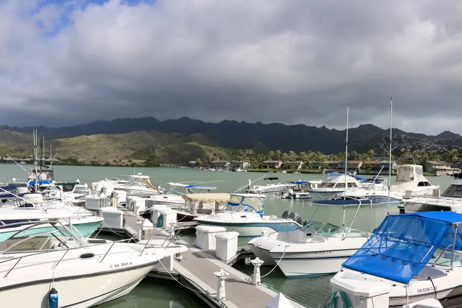 Boats tied up along the docks of Koko Marina with green Koolau ridges rising behind