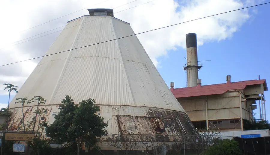 The old Waialua sugar mill with its tall smokestack against the sky