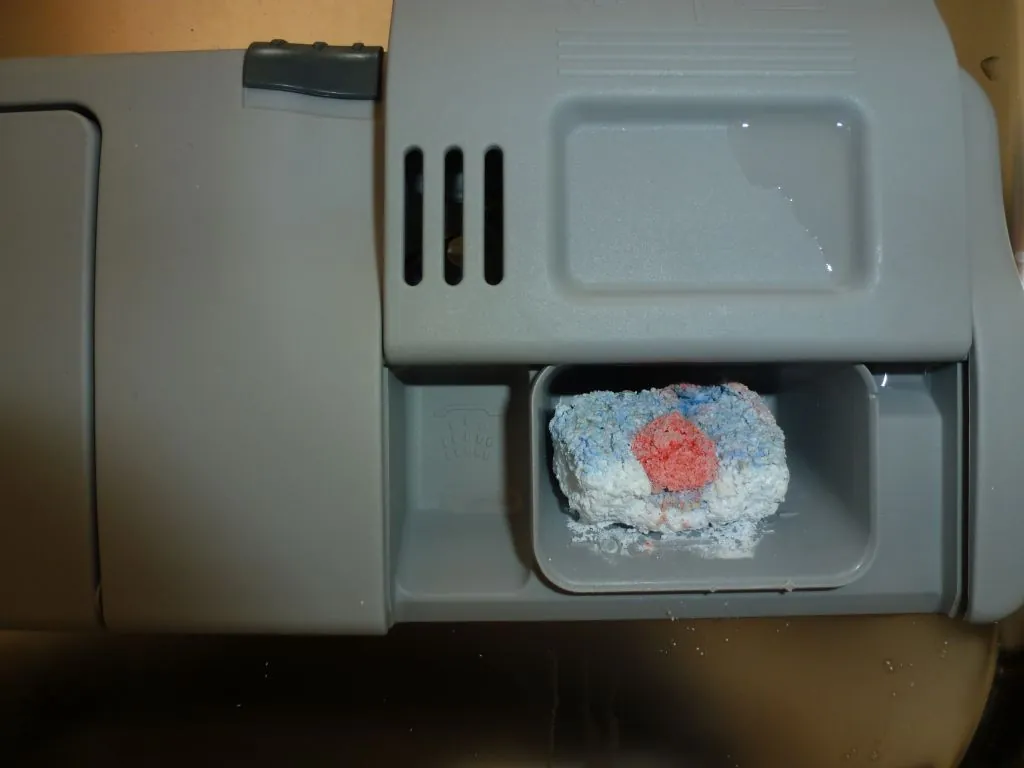 Dishwasher detergent cup still holding a tablet that never dissolved